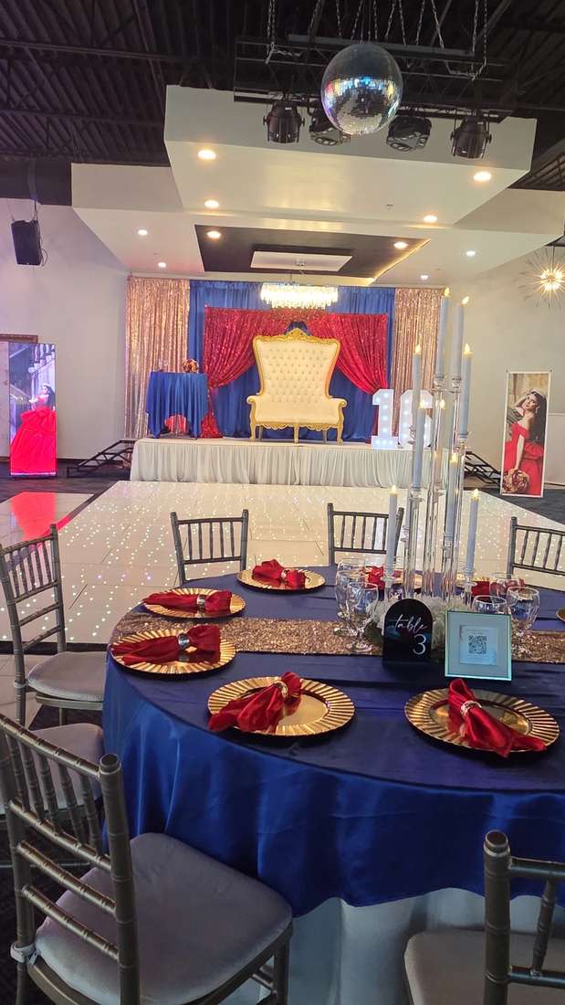 Navy and red banquet tables beside a gold throne stage at Silverstar Event Center in Lewisville, TX