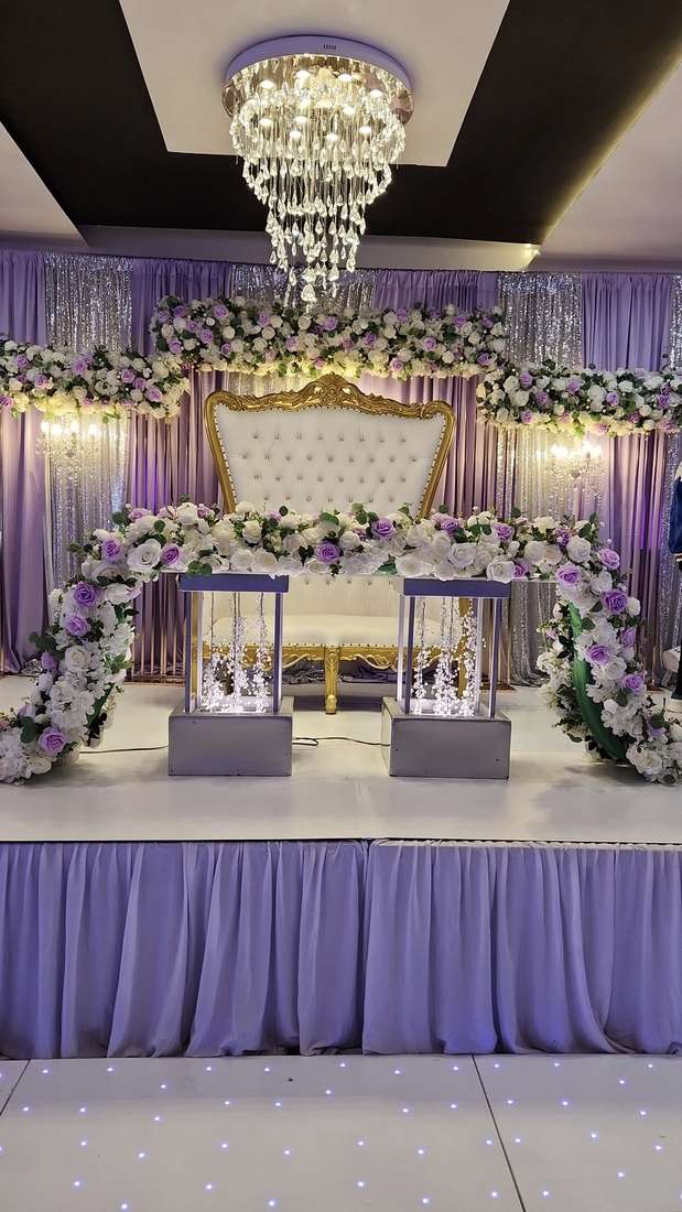 A gold and ivory throne chair beneath a lilac, white and green rose arch at Silverstar Event Center in Lewisville, TX