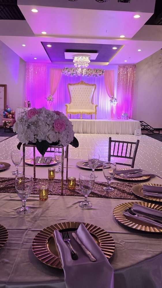 A white hydrangea and rose centrepiece on a gold stand above a mauve tablecloth at Silverstar Event Center in Lewisville, TX
