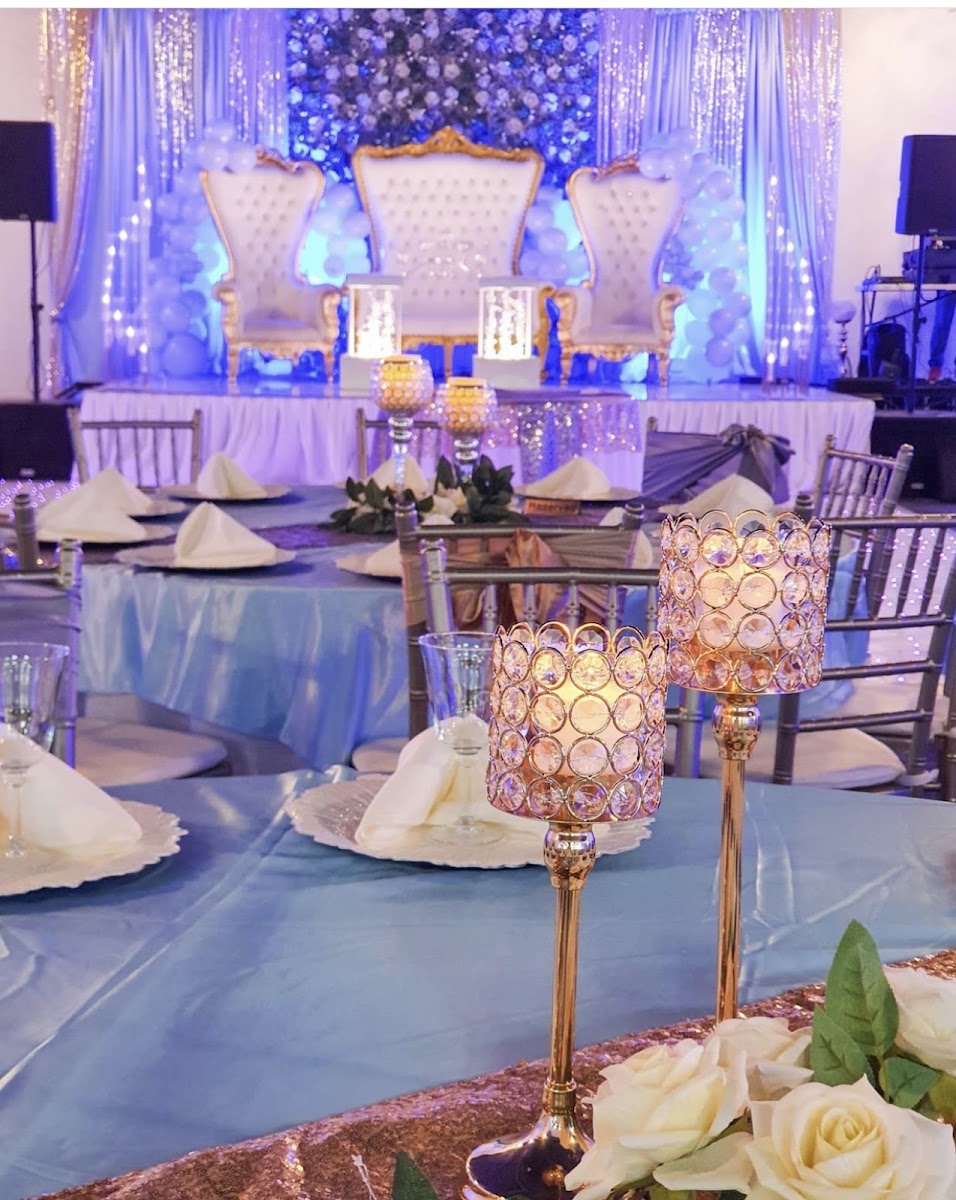 Sillas trono blancas y doradas sobre un escenario de globos azul y plateado en Silverstar Event Center, Lewisville, TX