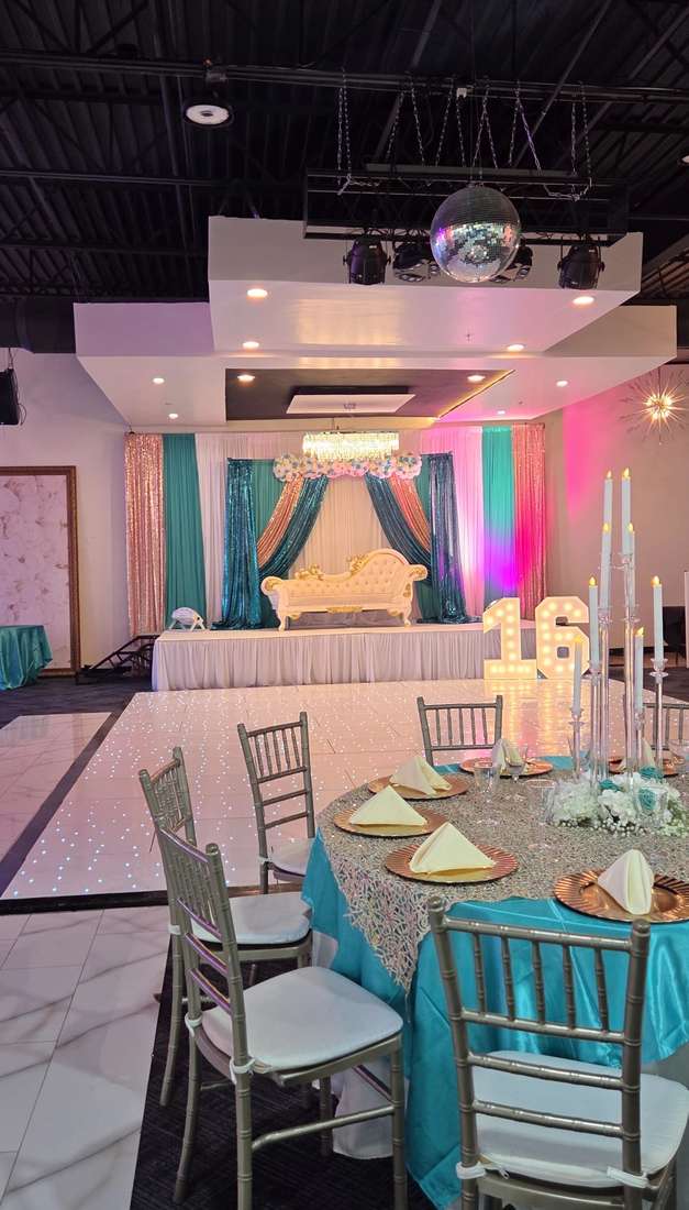 A teal and rose-gold Sweet 16 setup with a gold chaise, lit 16 marquee numbers and silver Chiavari chairs on a white LED dance floor at Silverstar Event Center in Lewisville, TX