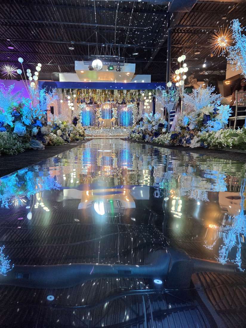 Close view of the mirrored aisle with lit floral arrangements at Silverstar Event Center in Lewisville, TX